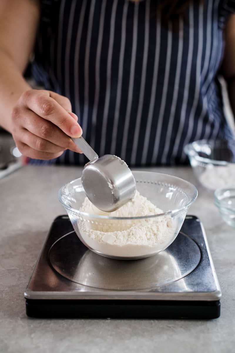 Meausuring flour into a baking scale.