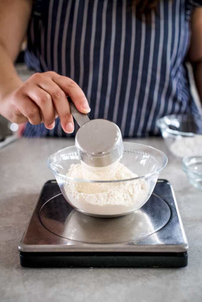 Measuring flour to make pie crust by hand.