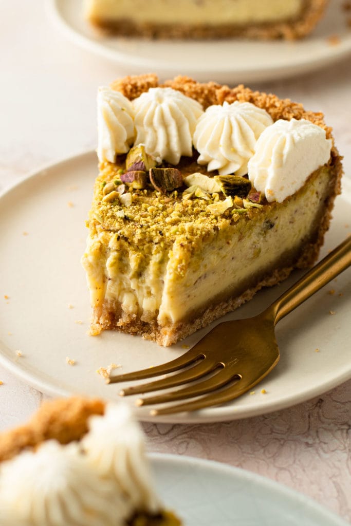 A slice of pistachio pie with a bit taken from it.