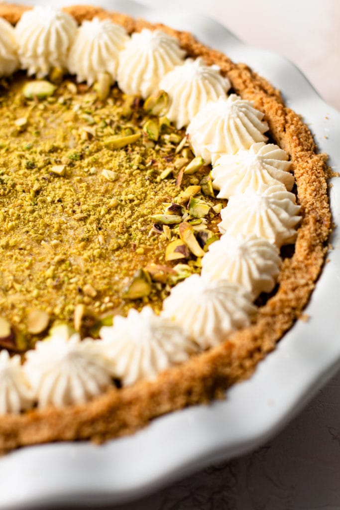 Pistachio pie with a decorative whipped cream edge.