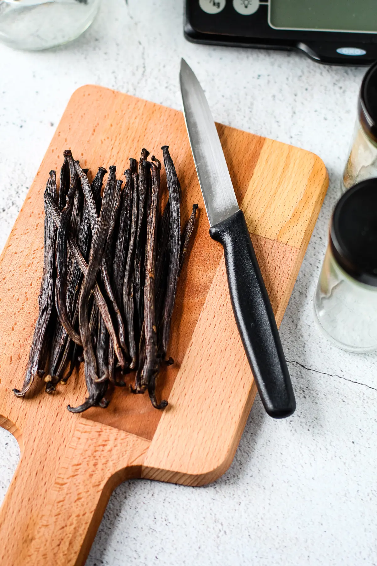 Whole vanilla beans on a cutting board for vanilla extract