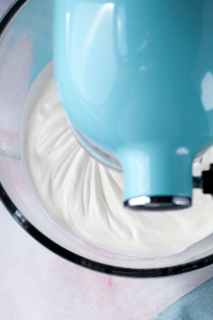 Whipped cream in an electric mixer.