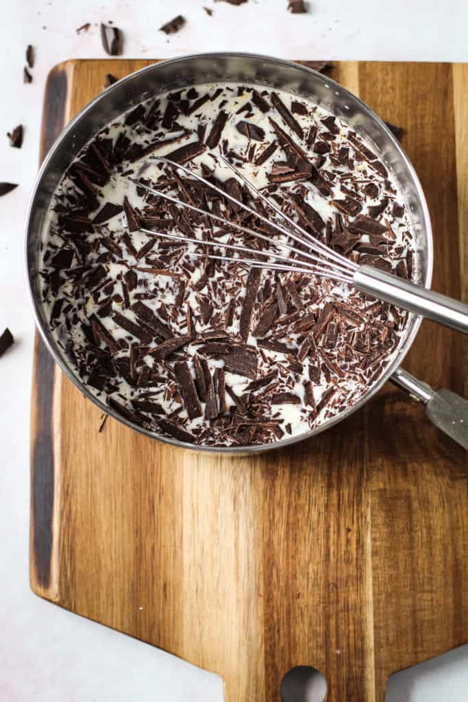 Chopped chocolate in a pot with milk.