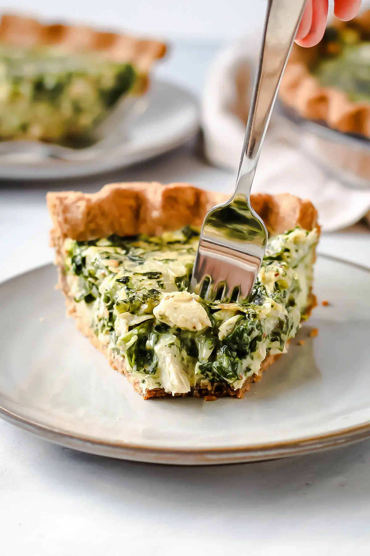 A slice of artichoke pie with a fork taking out a bite.