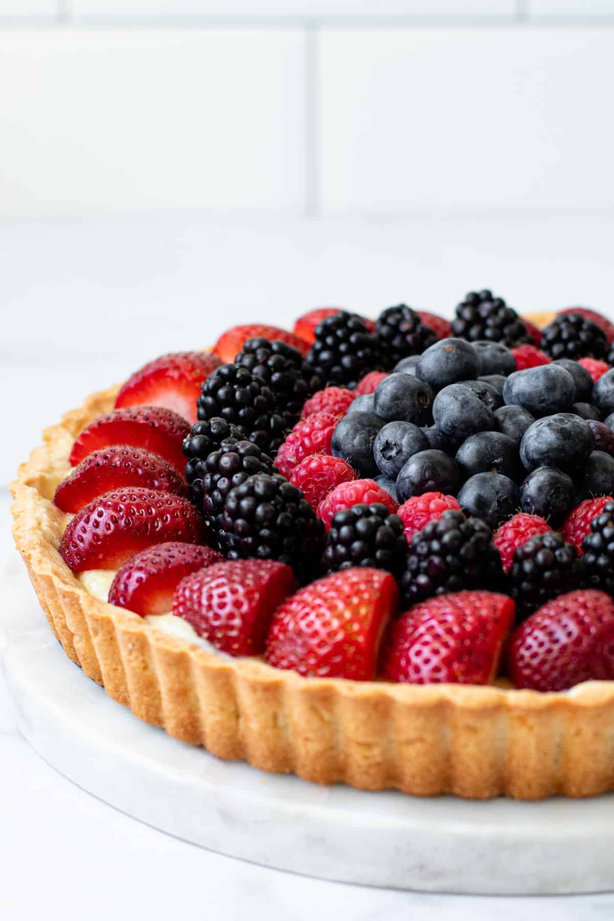 A side view of a classic fruit tart.