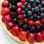 A glazed fresh fruit tart filled to the top with berries.