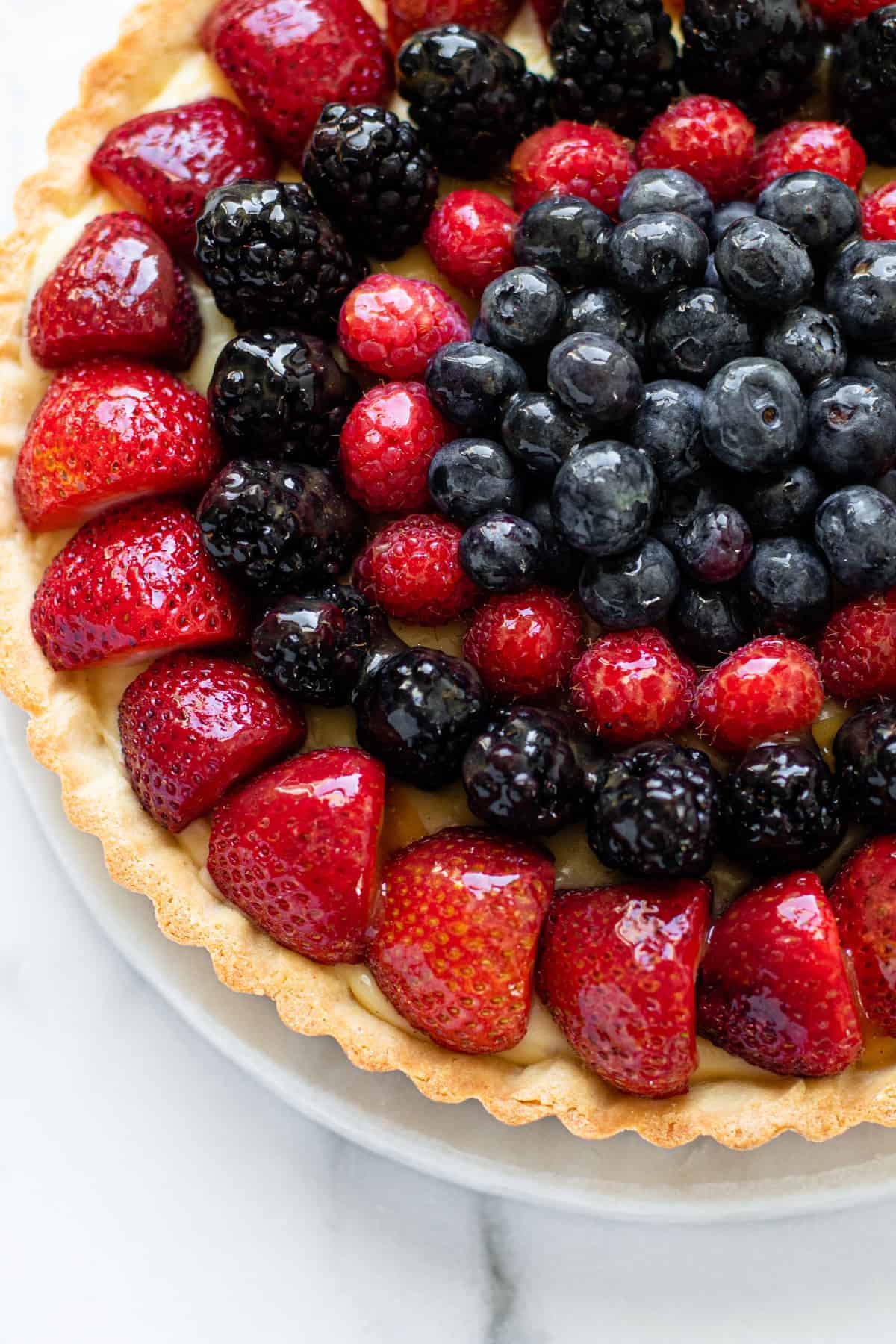 A glazed fresh fruit tart filled to the top with berries.
