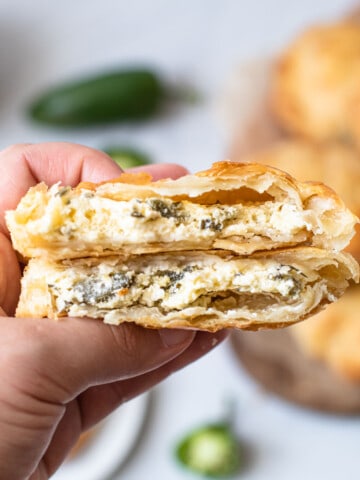 Jalapeno popper hand pies broken in half to expose the filling.