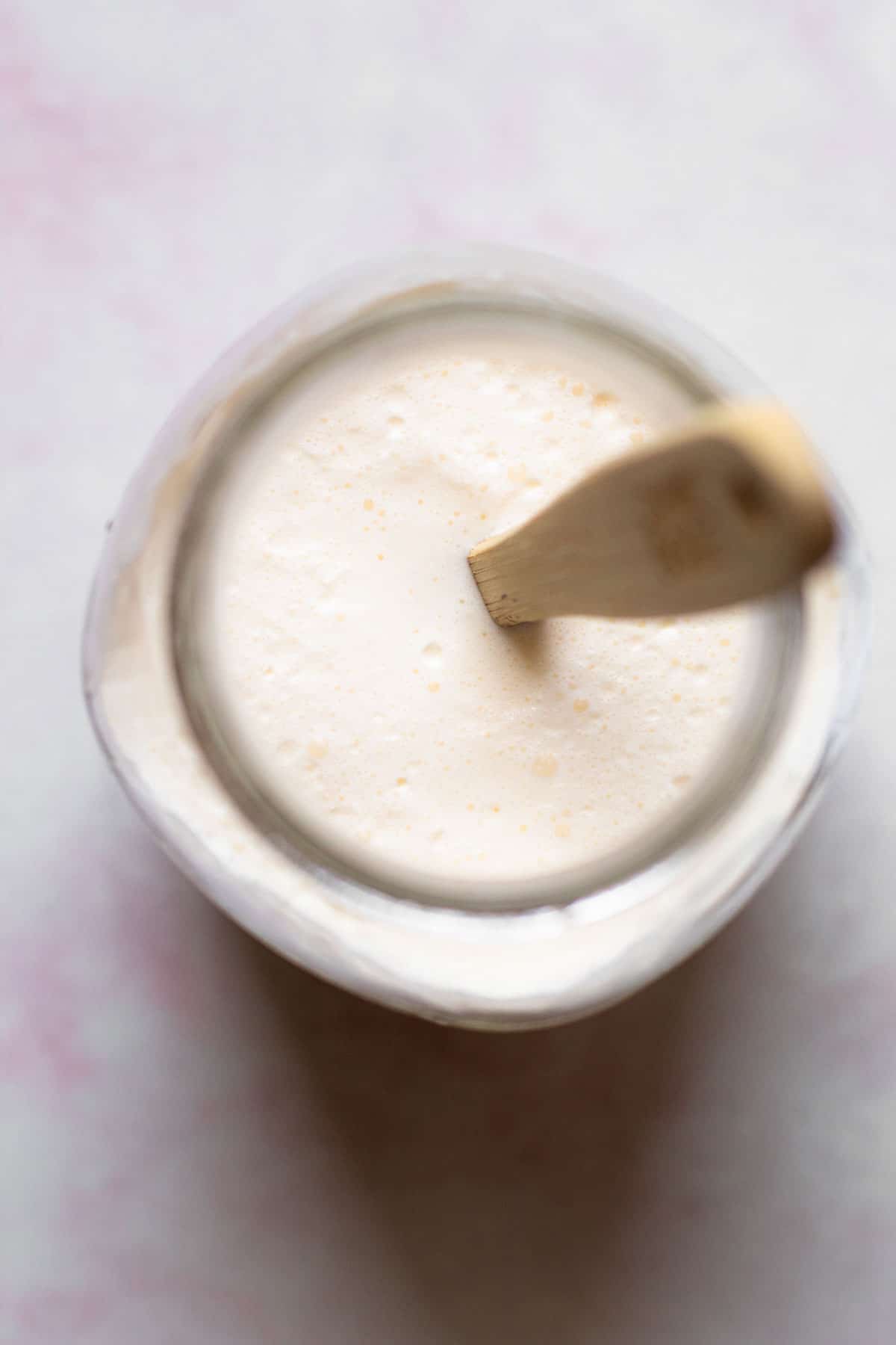 A jar full of fermenting creme fraiche.