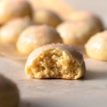 An Italian anise cookie with a glaze displayed with a bite taken out of it.