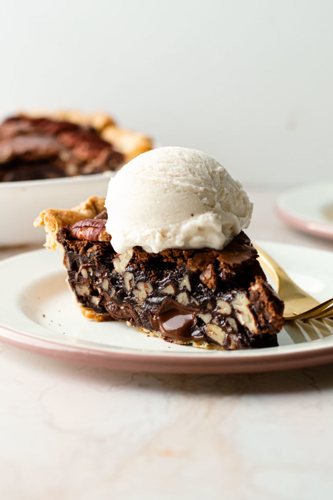 A slice of brownie pecan pie with ice cream on top.