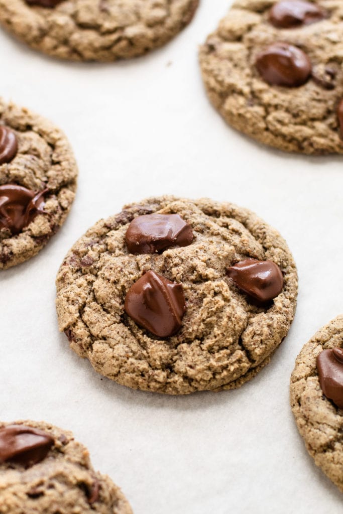 A chocolate chip cookie on a sheet tray, made from oat flour and buckwheat flour.