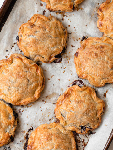 Blueberry hand pies on a baking tray.