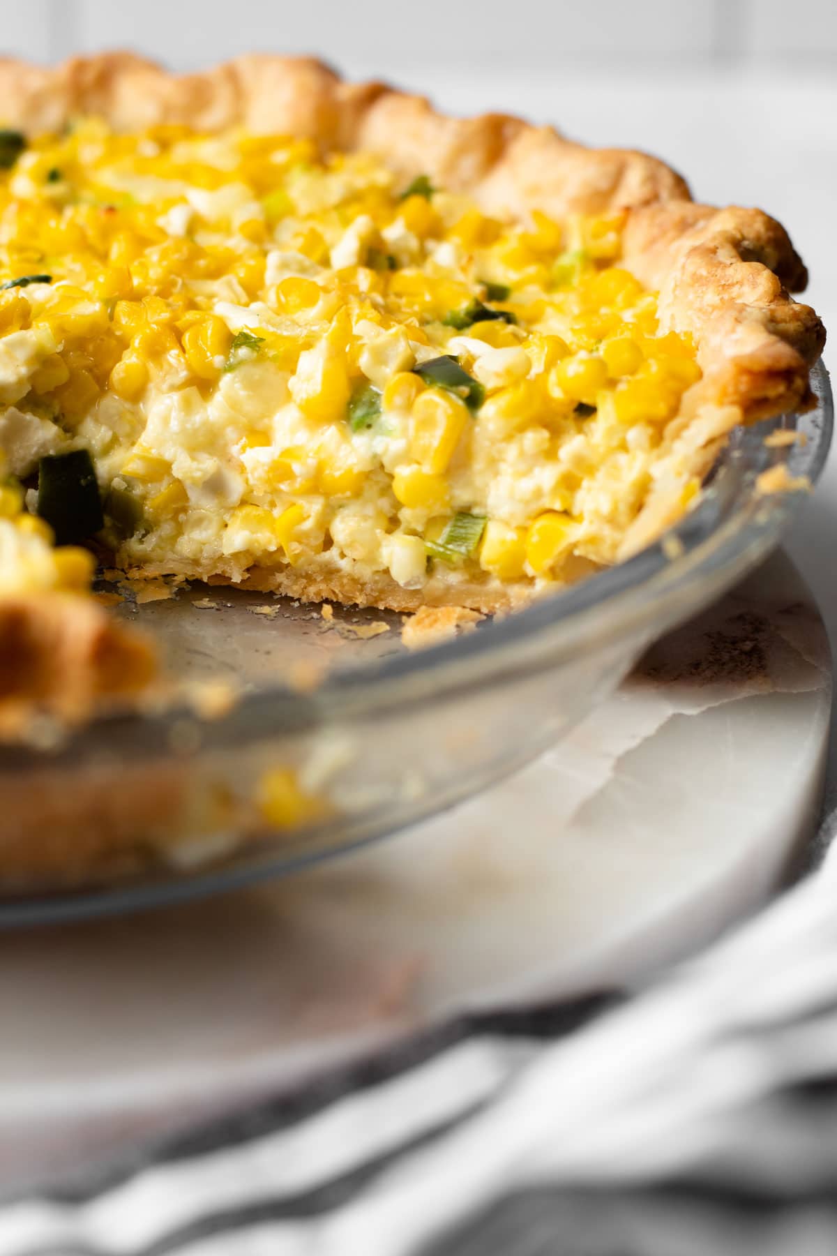 Fresh corn pie sliced up in a pie dish.