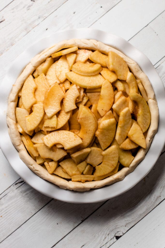 A gluten free pie crust filled with unbaked apple pie filling.