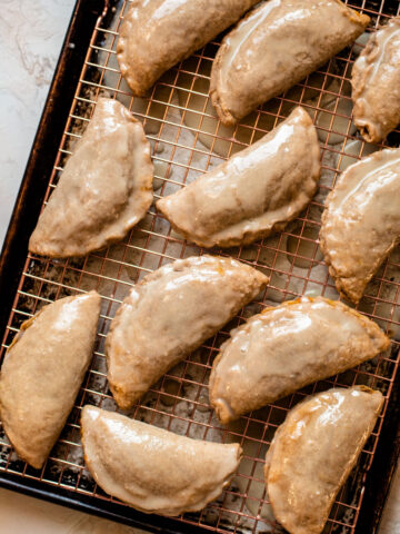 Pumpkin pasties inspired by harry potter sitting glazed on a sheet tray.