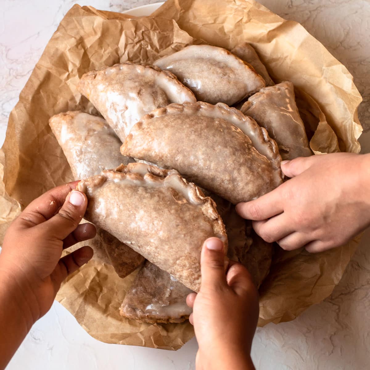Kids hands picking up pumpkin pasties inspired by harry potter.