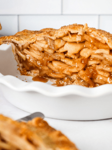 Mile high apple pie in a pie plate.