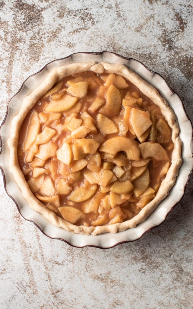 A double crust apple pie without the top crust unbaked.
