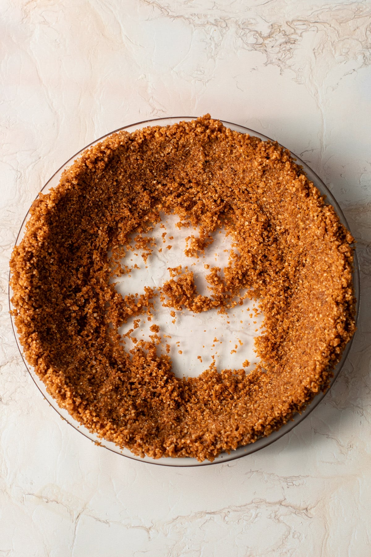 Gingersnap crumbs in a pie crust with the edges formed first.