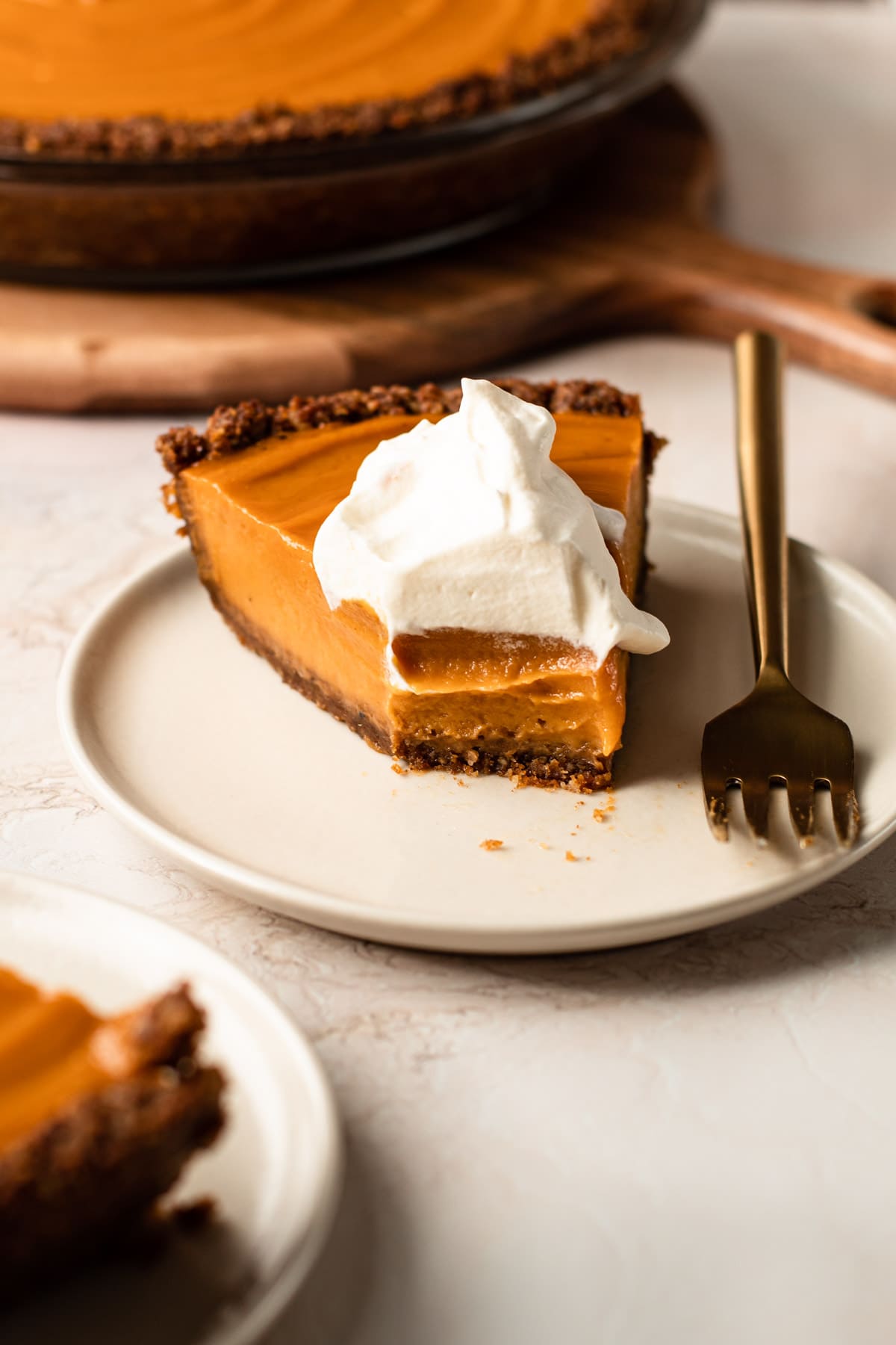 A slice of sweet potato pie with whipped cream on top.