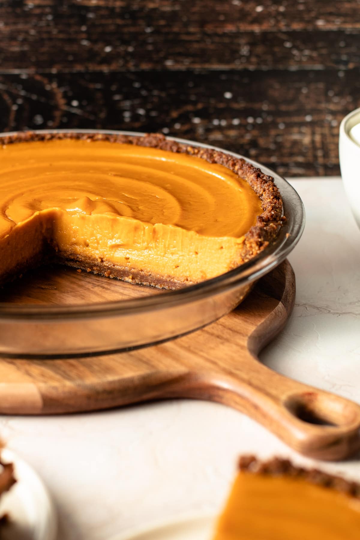 Sweet potato pie with a slice cut out to reveal the creamy center.