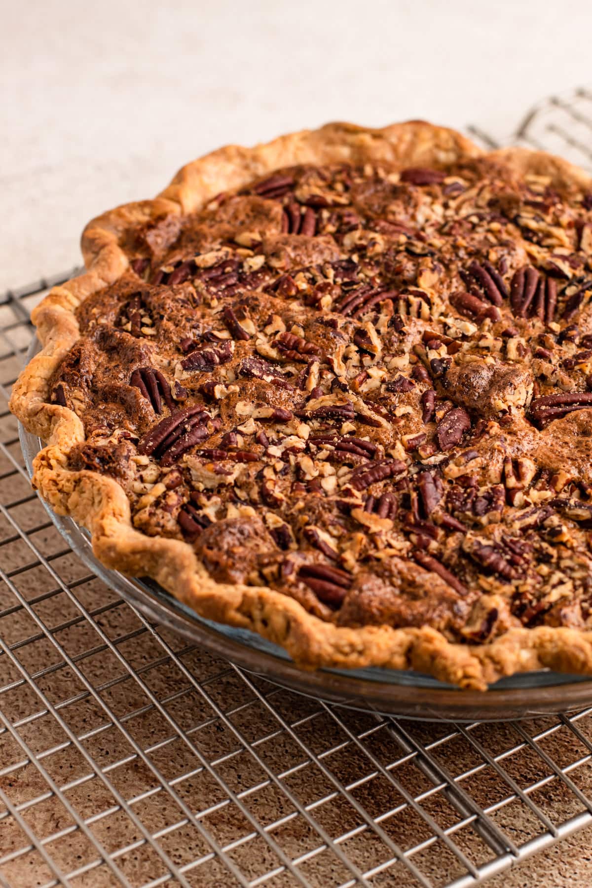 A baked bourbon pecan pie made without corn syrup on a cooling rack.