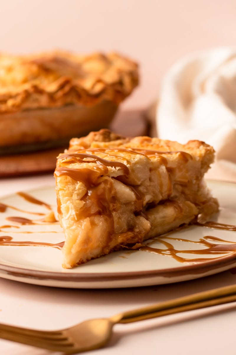 A slice of pear pie with butterscotch drizzled on it.