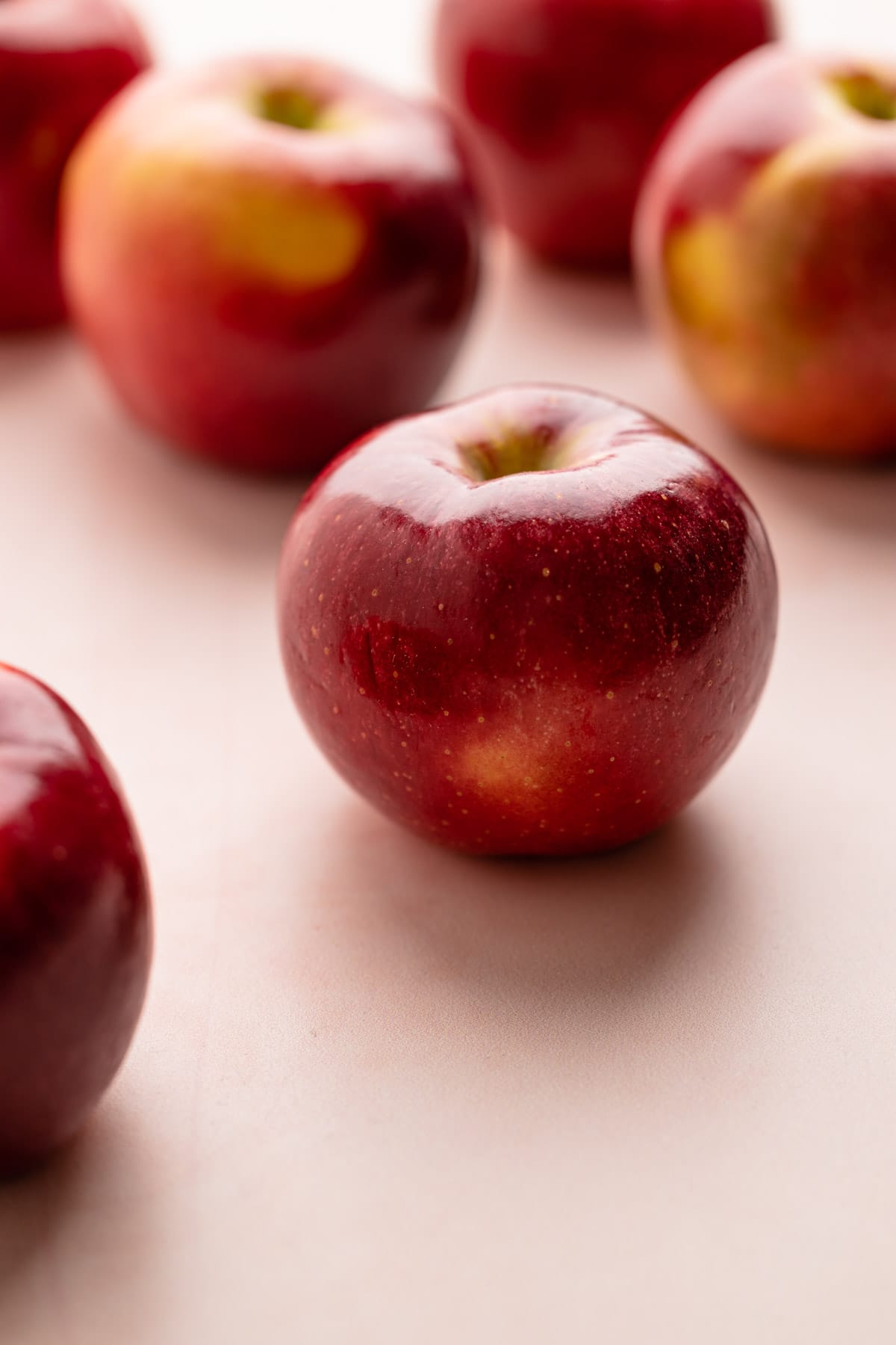 Ruby red apples on a pink background.