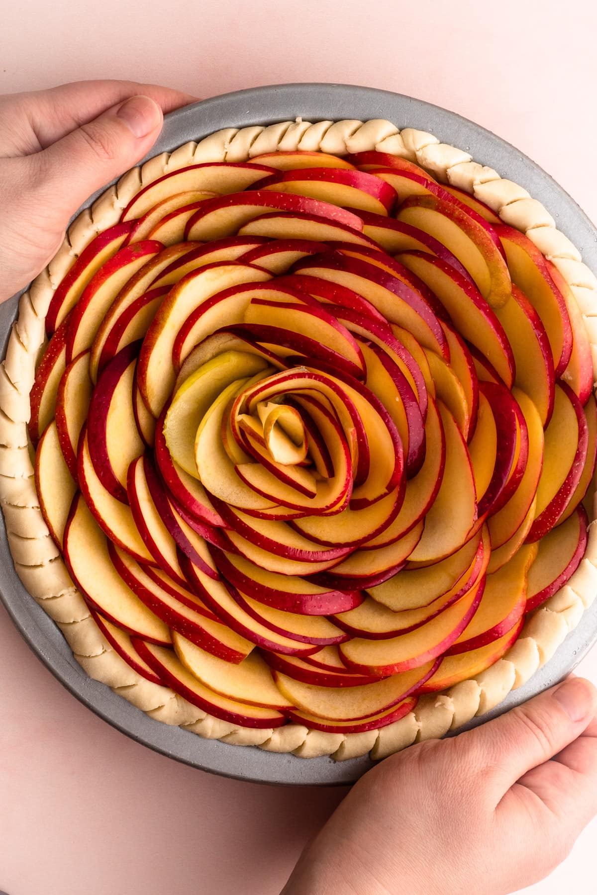 An assembled but unbaked apple rose pie.