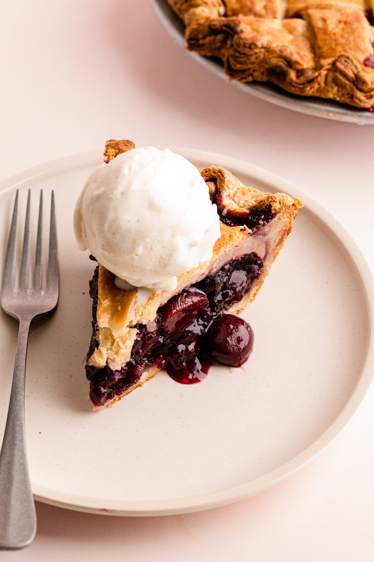 A slice of sweet cherry pie made with frozen cherries.