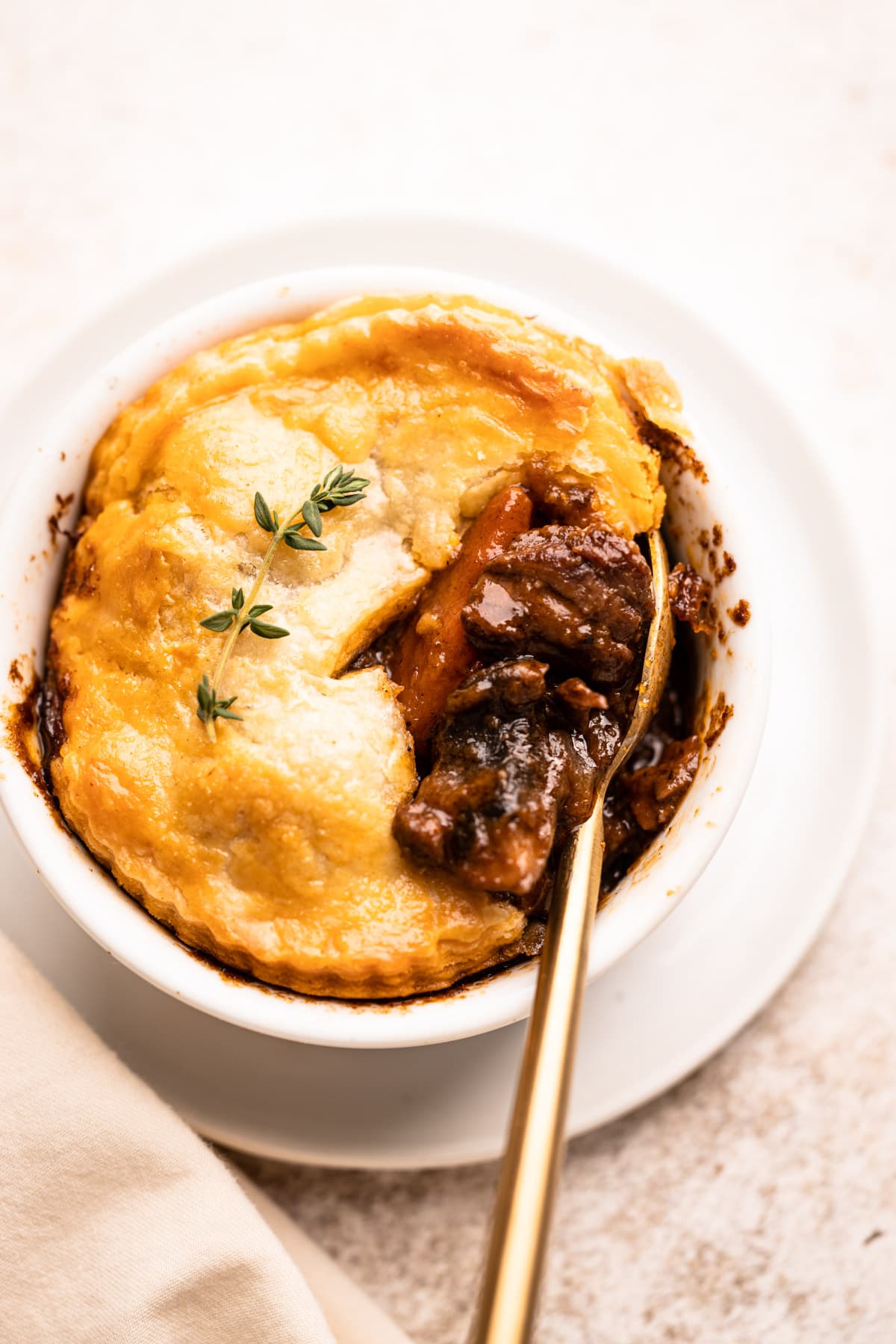 A beef pot pie in an individual ramekin.