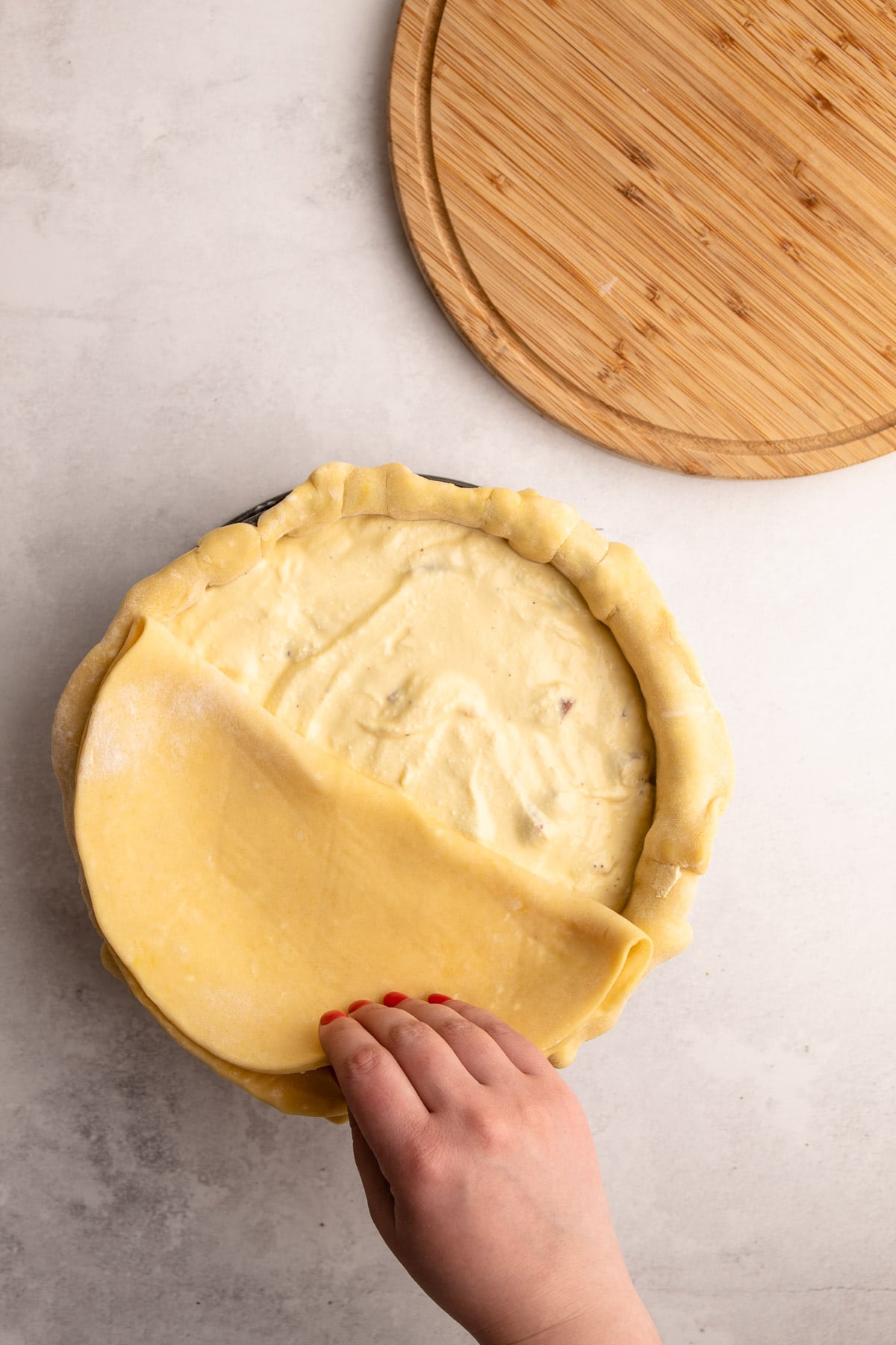 A pizza rustica being assembled.