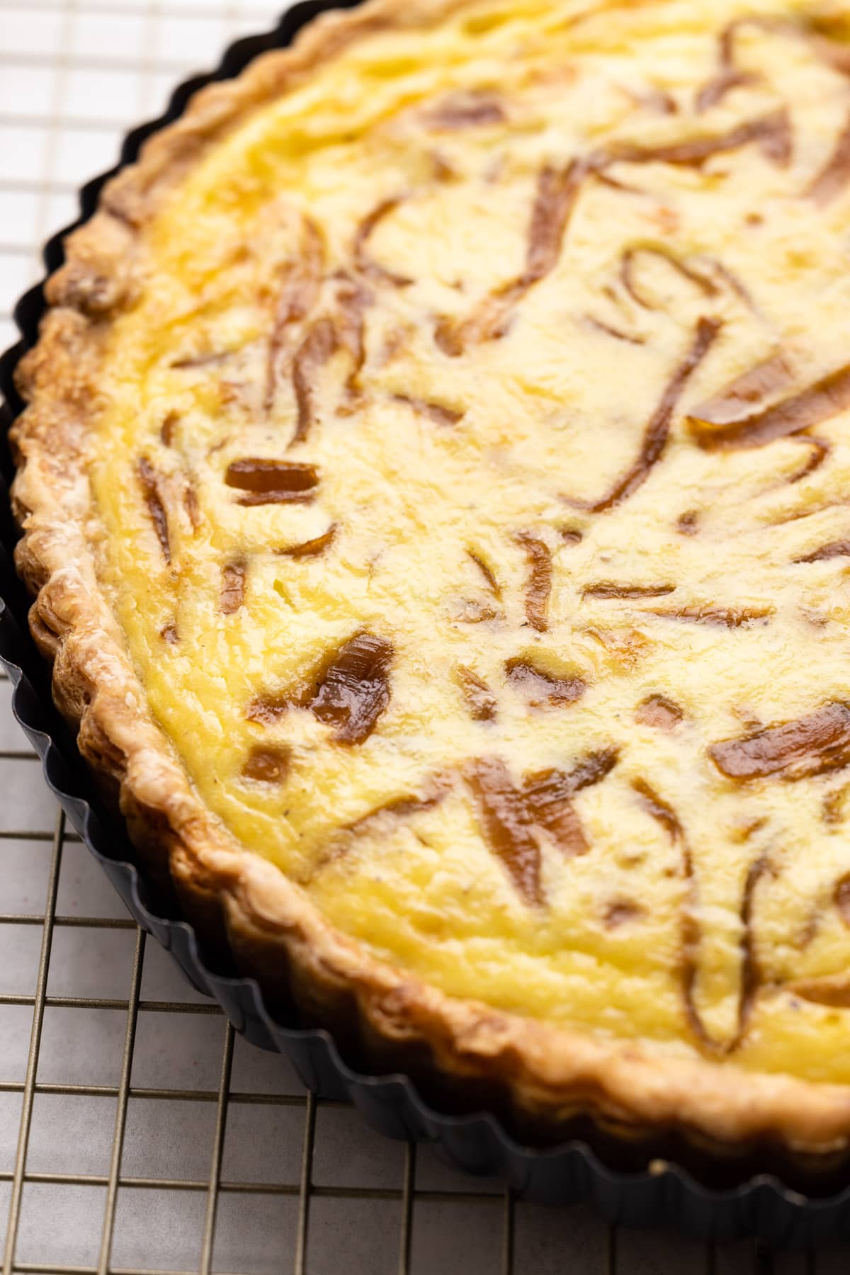 A fully baked and puff caramelized onion quiche.