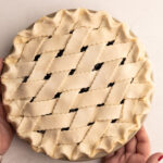 An unbaked pie with a lattice crust made with a sour cream pie crust.