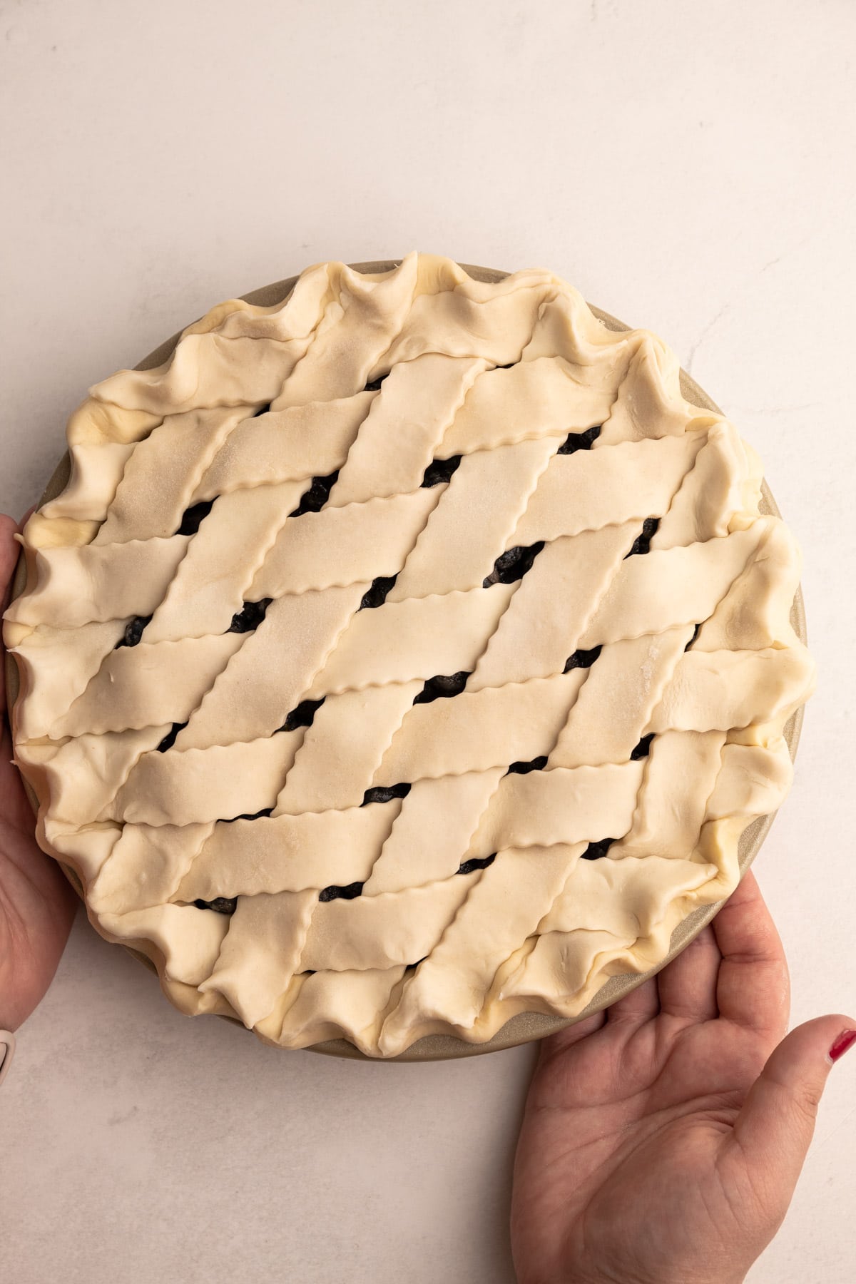 An unbaked pie with a lattice crust made with a sour cream pie crust.