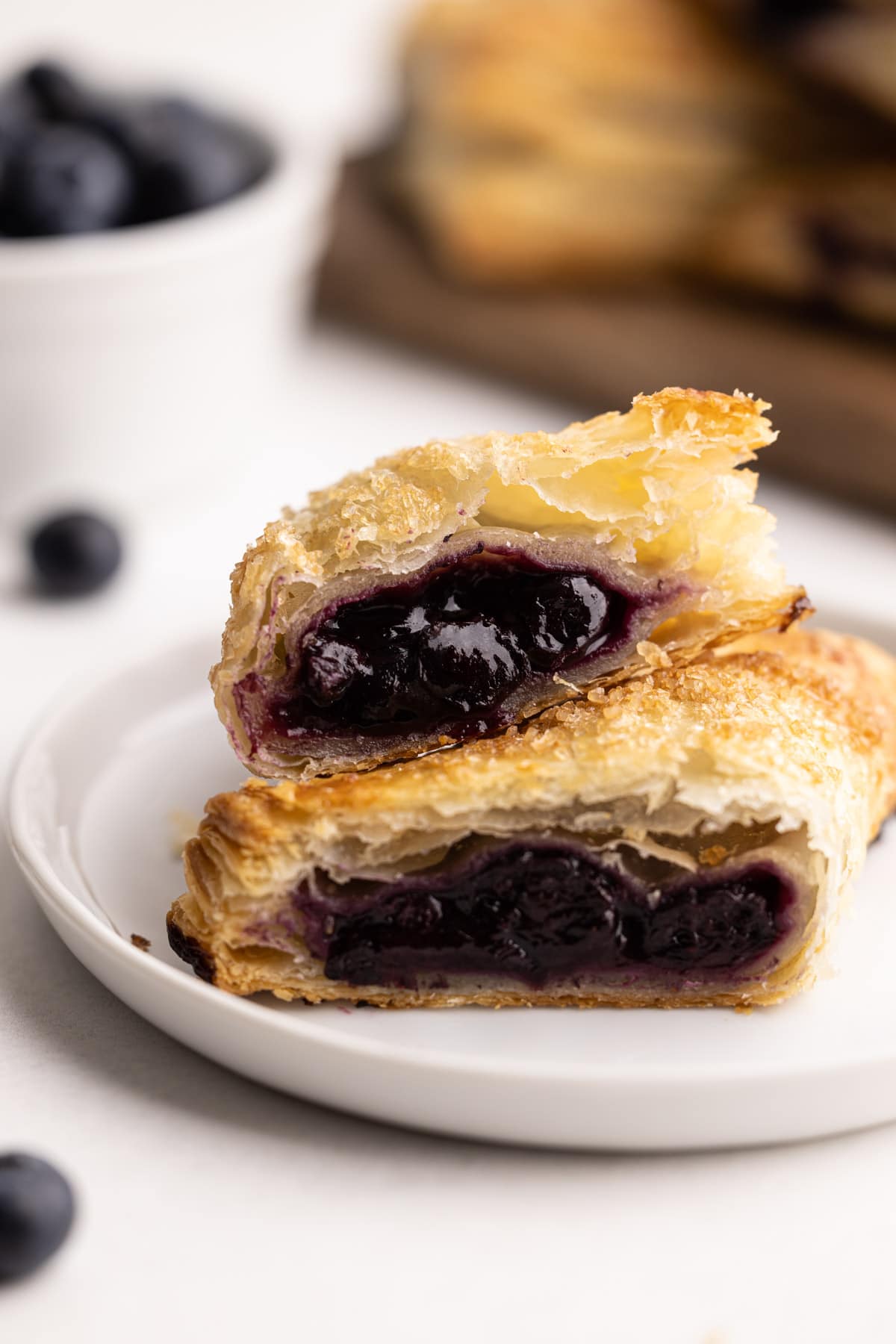 A blueberry turnover sliced in half to reveal a juicy blueberry filling.