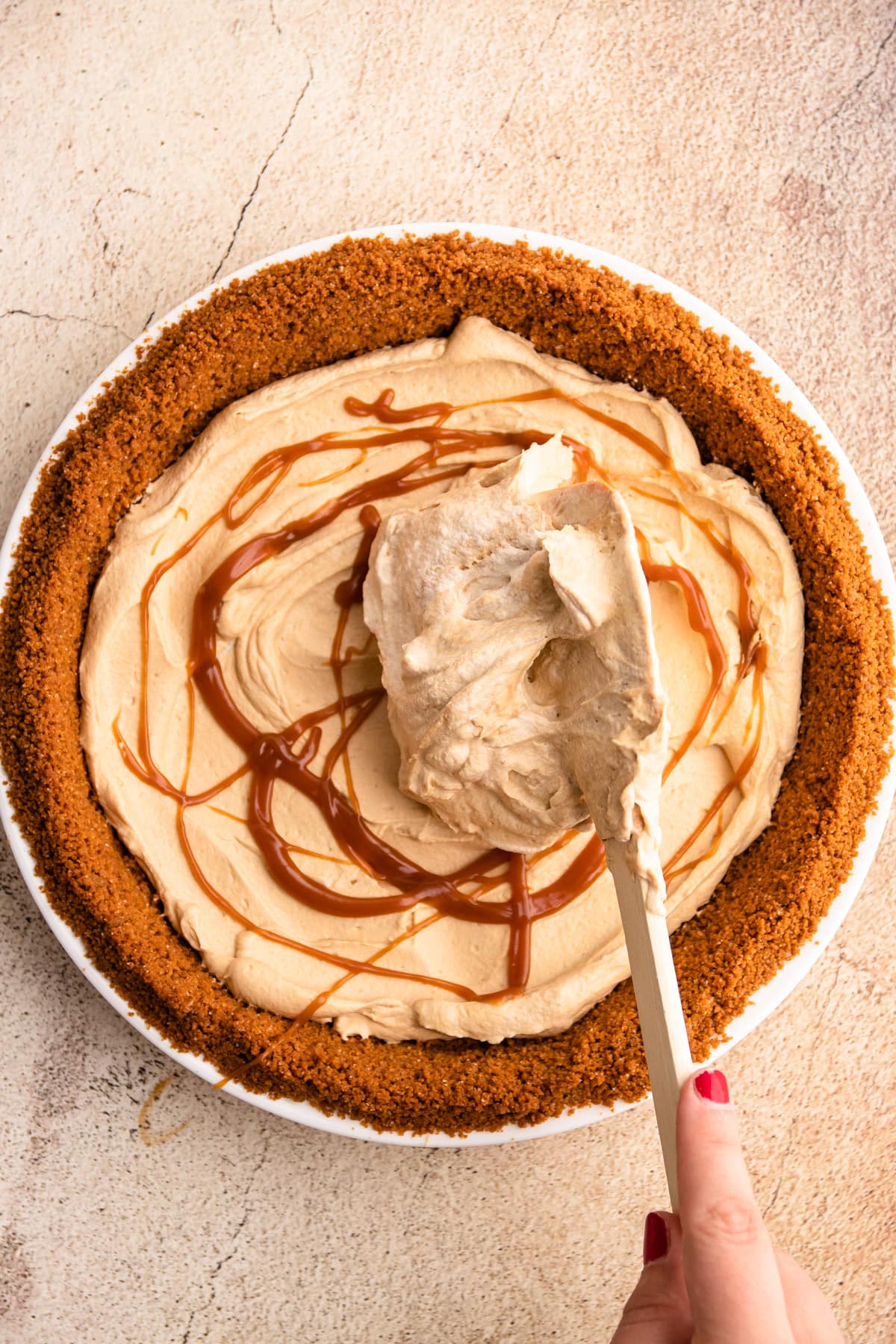 Assembling a caramel macchiato pie.