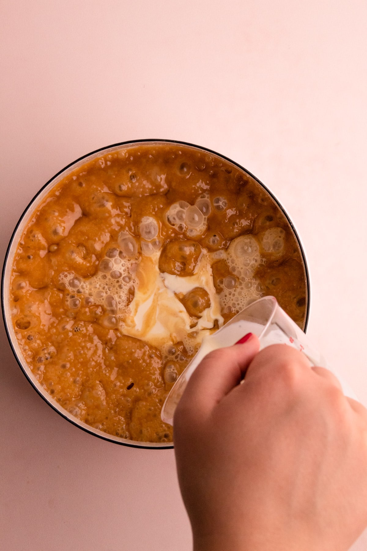 Adding cream to a Carmel sauce.