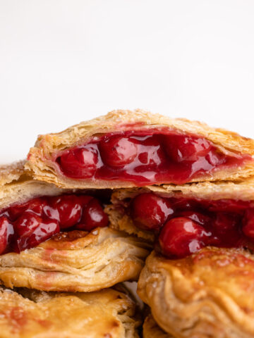 Cherry hand pie broke open on a cutting board.