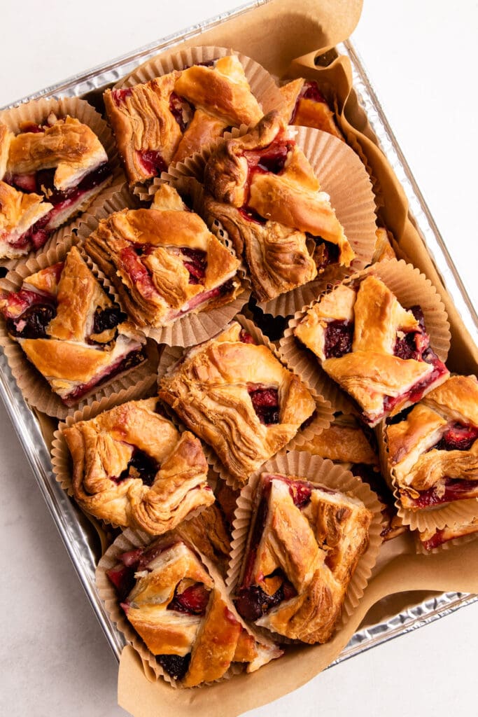 Slices of cherry strawberry slab pie cut inside of muffin cups for easy serving.