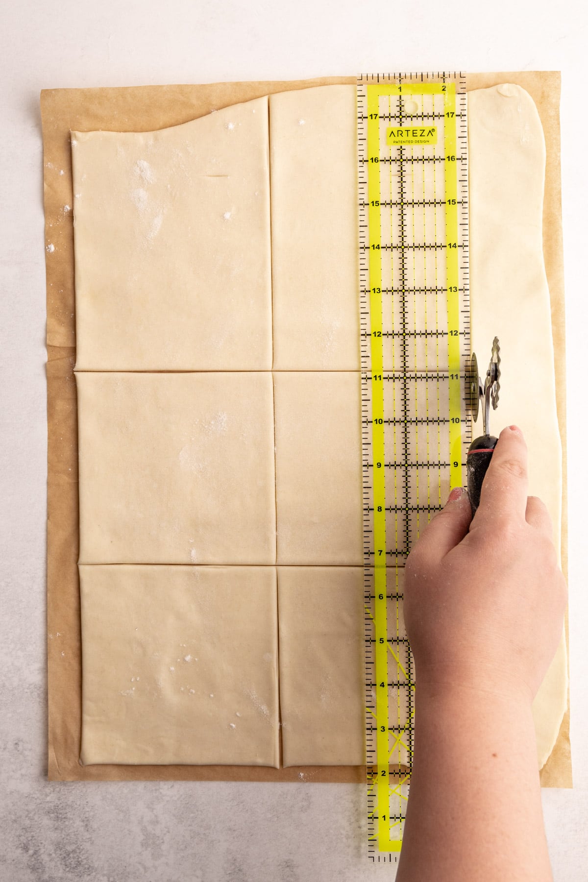 Squares of dough being cut out for turnovers.