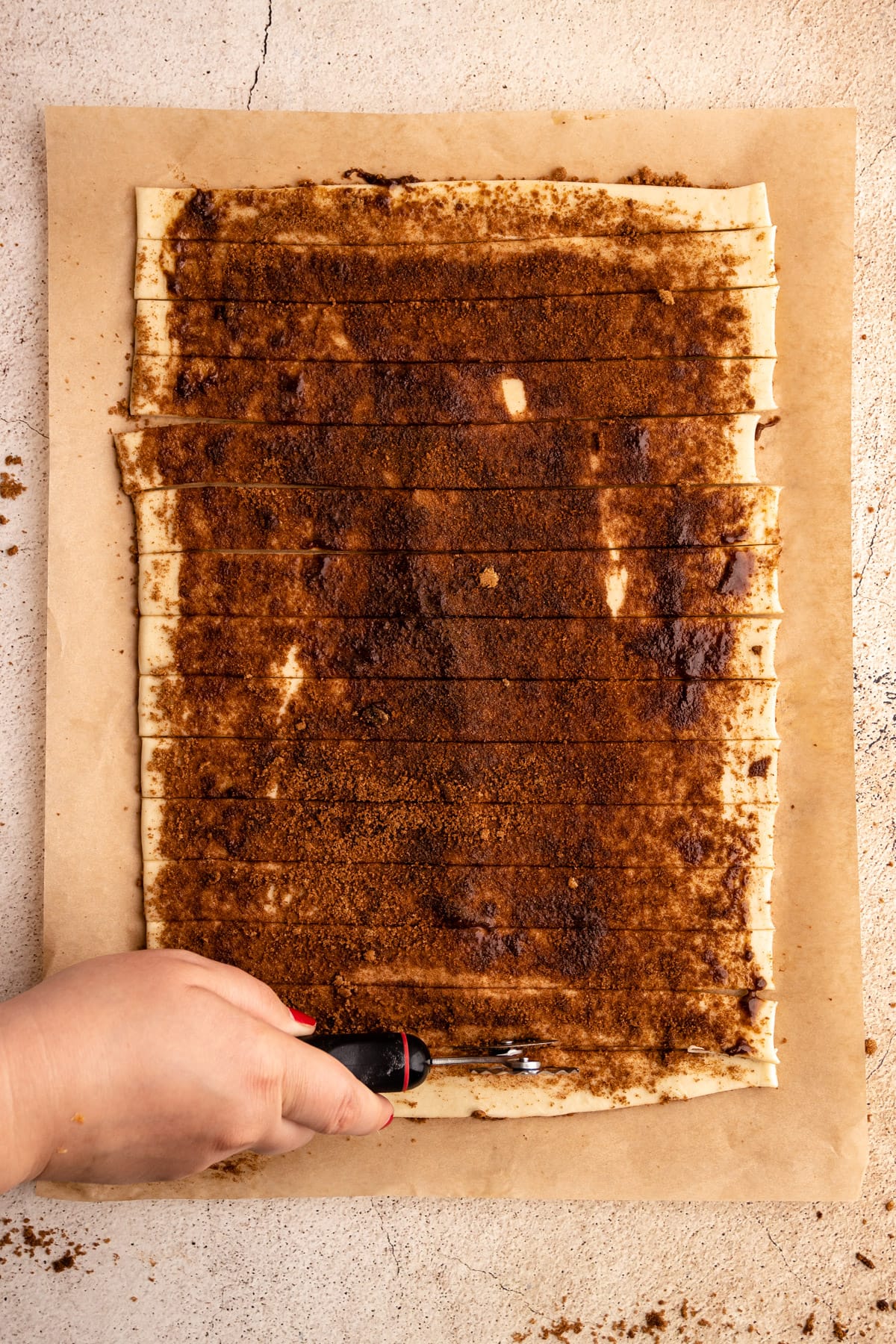 Cutting cinnamon twists into strips.