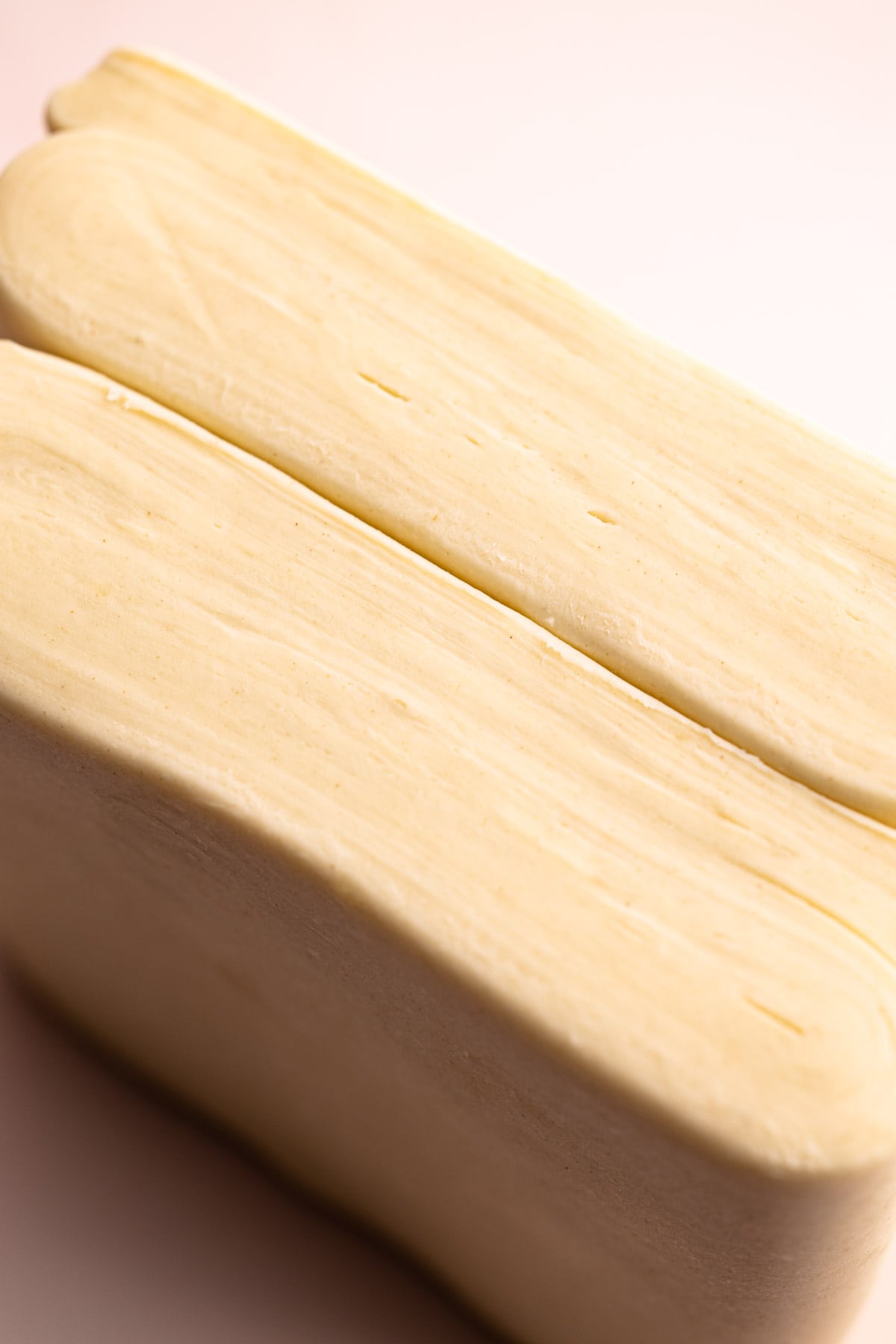 Two slabs of ruff puff revealed to show layers of dough and butter.