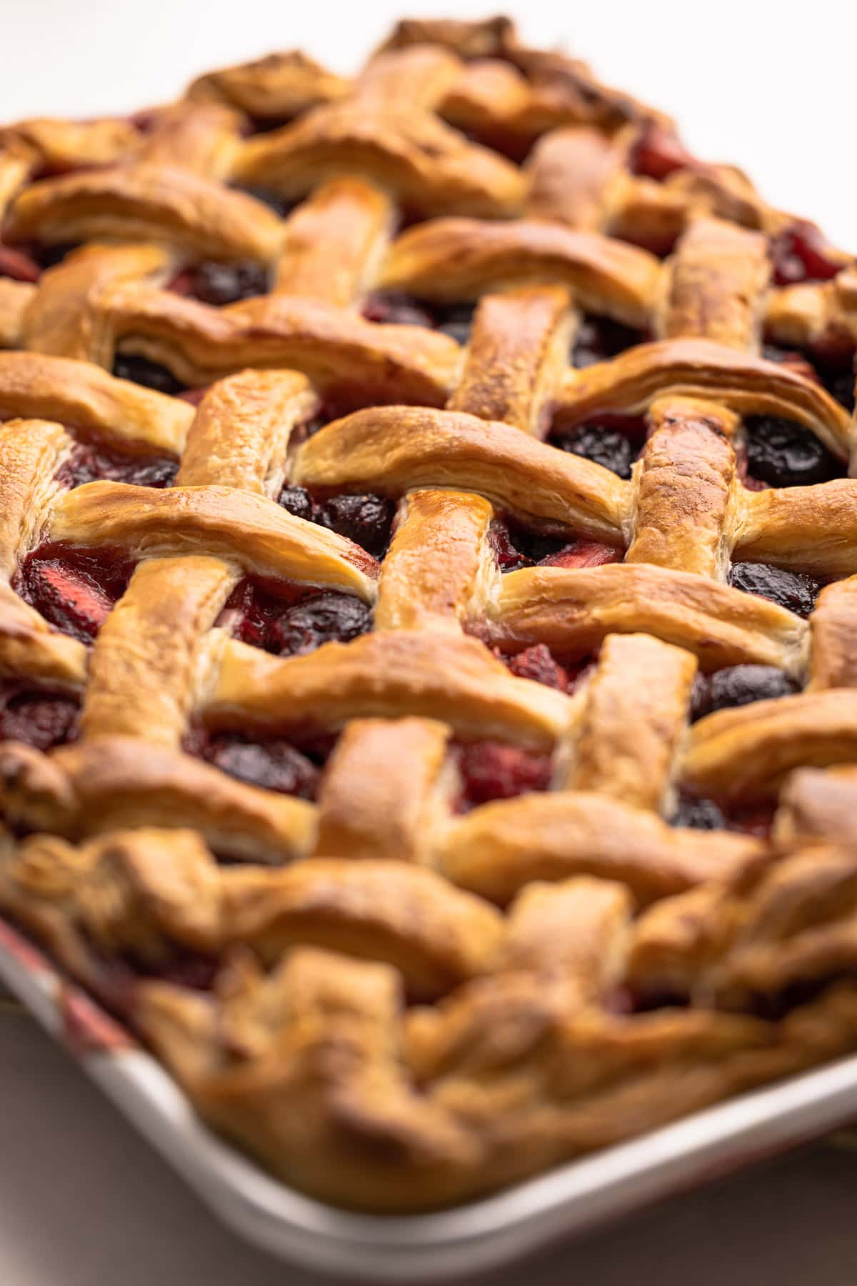 Cherry Strawberry Slab Pie baked in a sheet pan with a lattice top.