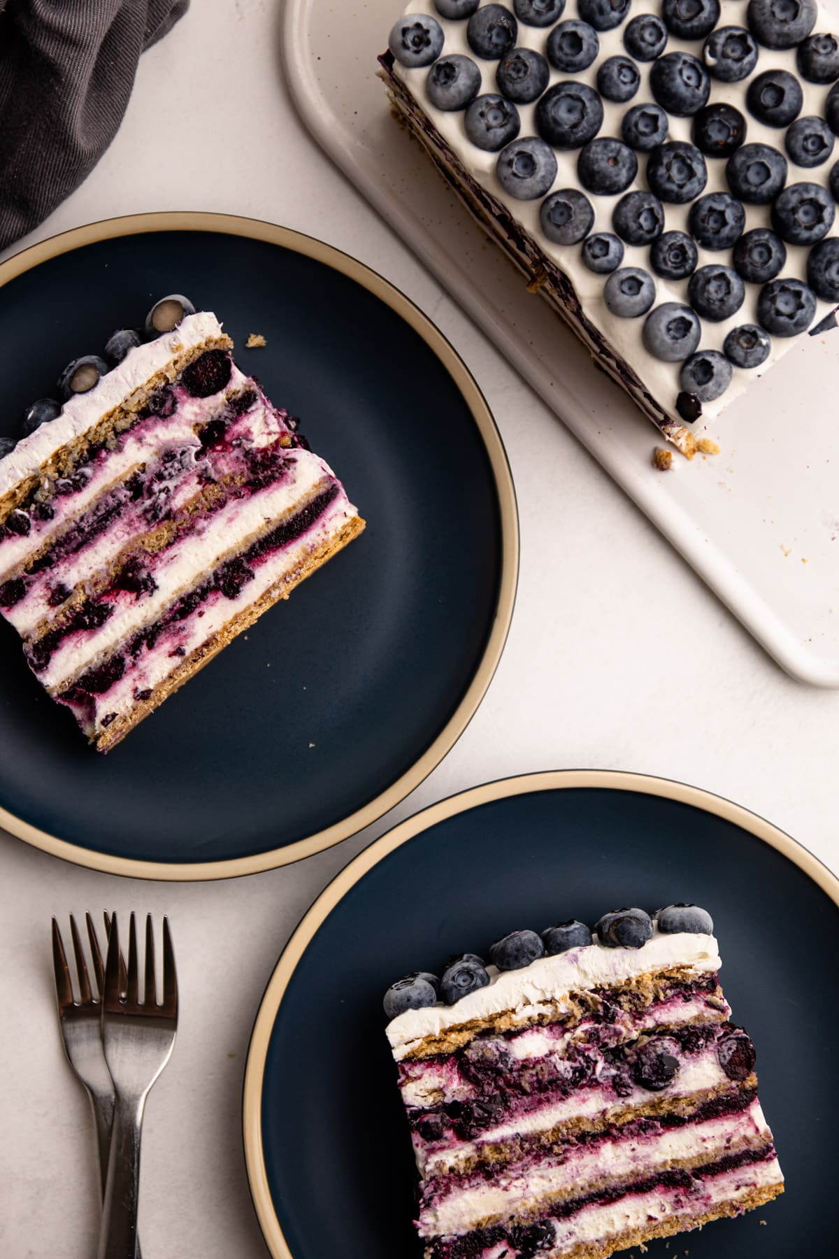 Slices of blueberry icebox cake on blue plates.