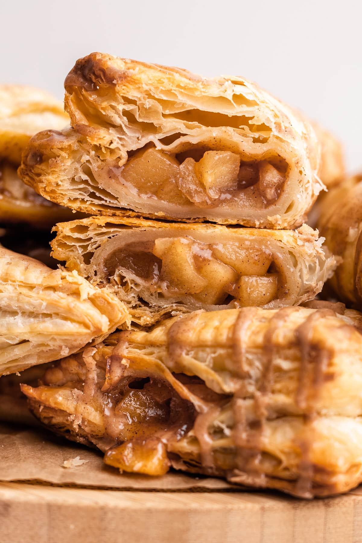 Apple turnovers stacked on top of each other and cut open.