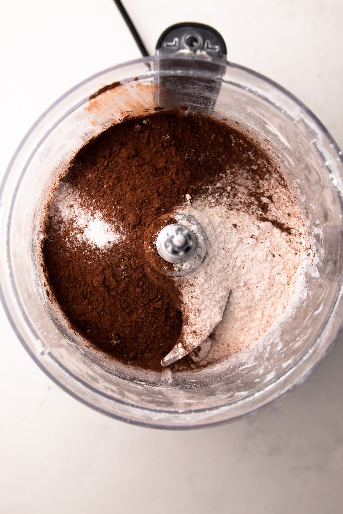 The dry ingredients in a food processor for a chocolate pie crust.