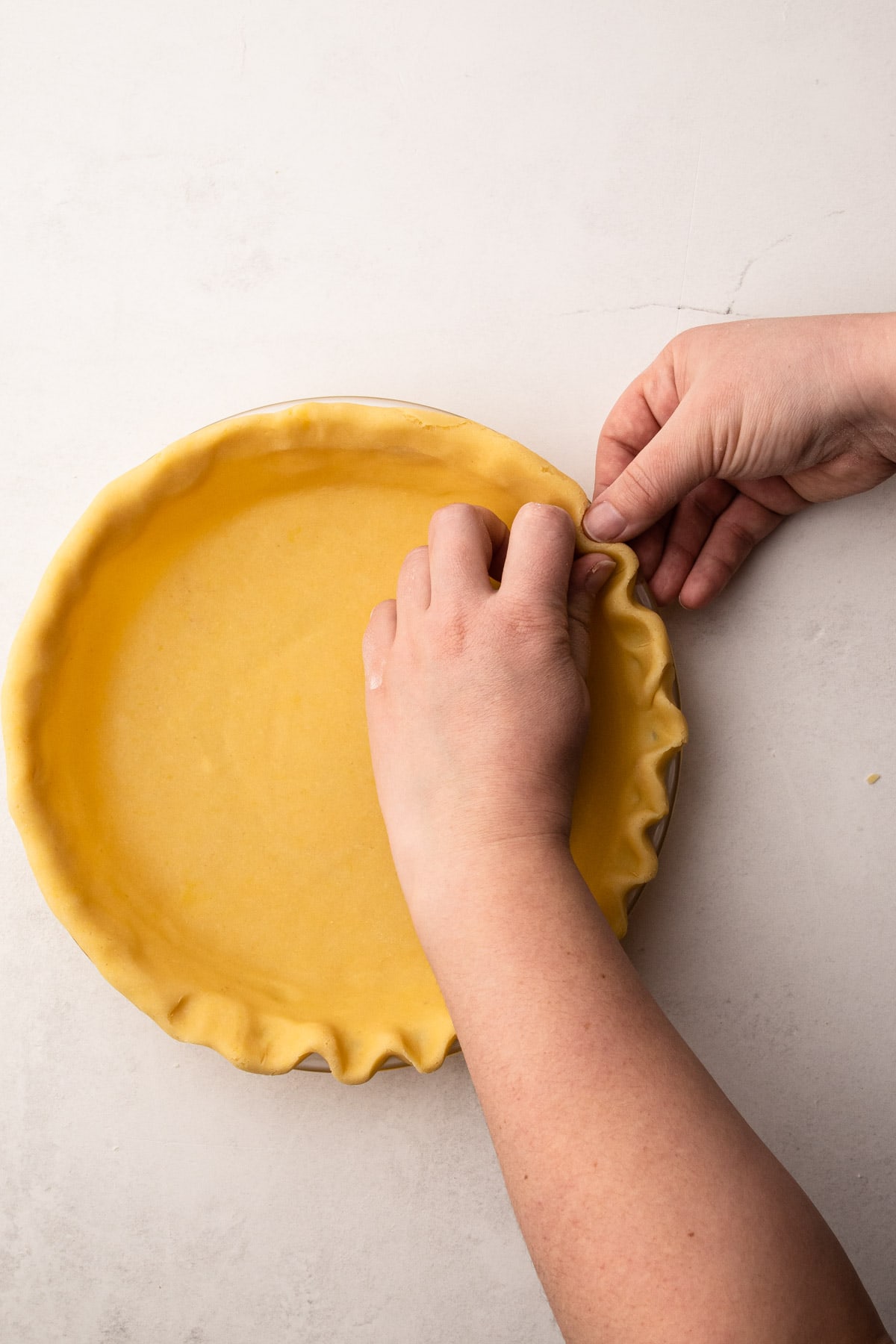 Crimping the edges of a shortbread pastry.