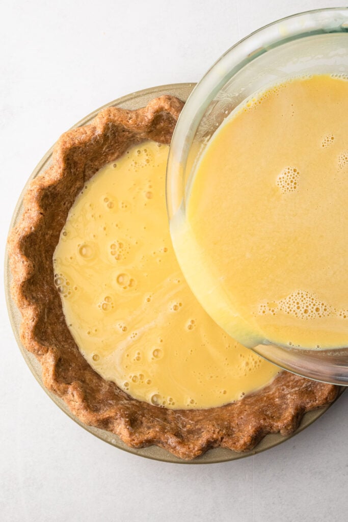 Pouring the maple filling into the pie crust.